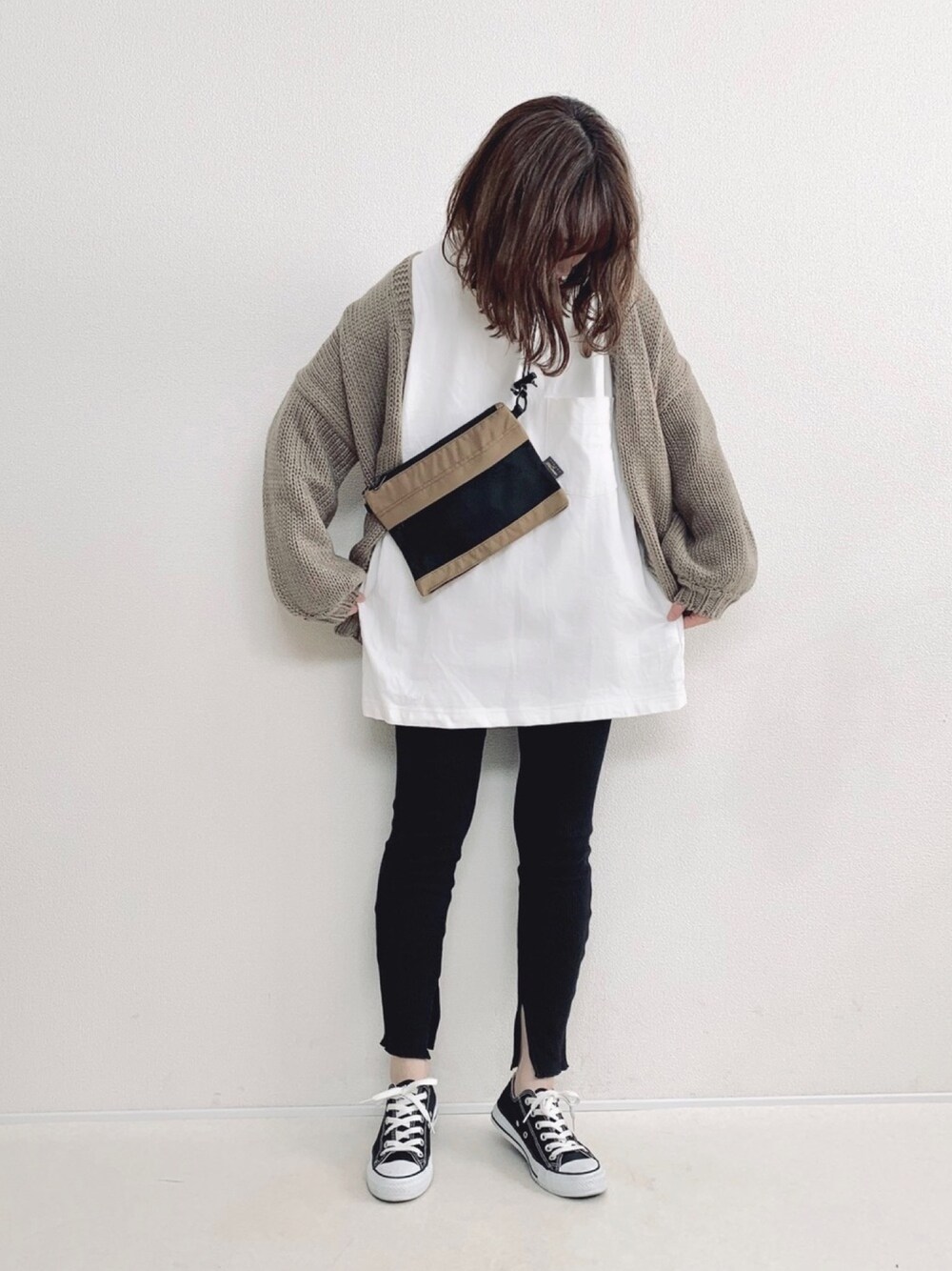 ベージュ系のショルダーバッグ、ホワイト系のTシャツ/カットソー、ベージュ系のカーディガン/ボレロを着用したレディースの冬コーディネートの1枚目の写真