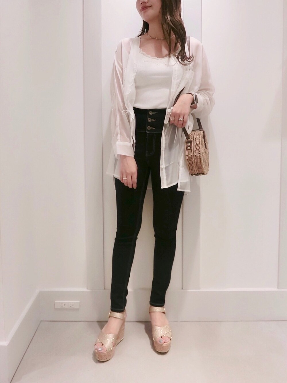 ブルー系のデニムパンツ、ブラウン系のショルダーバッグ、ホワイト系のキャミソールを着用したレディースの夏コーディネートの1枚目の写真