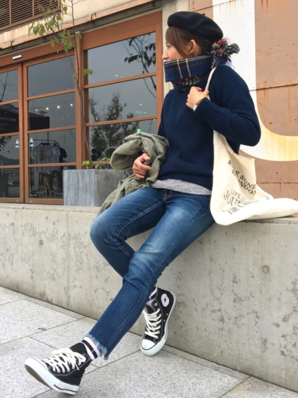 ブルー系のニット/セーター、ブルー系のデニムパンツ、ブラック系のスニーカーを着用したレディースの秋コーディネートの1枚目の写真