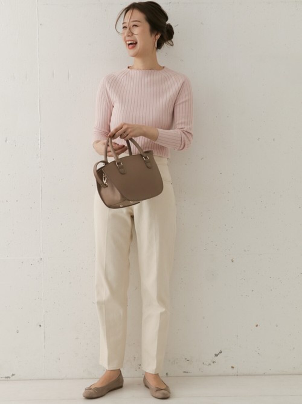 ピンク系のニット/セーター、ベージュ系のデニムパンツを着用したレディースの冬コーディネートの1枚目の写真