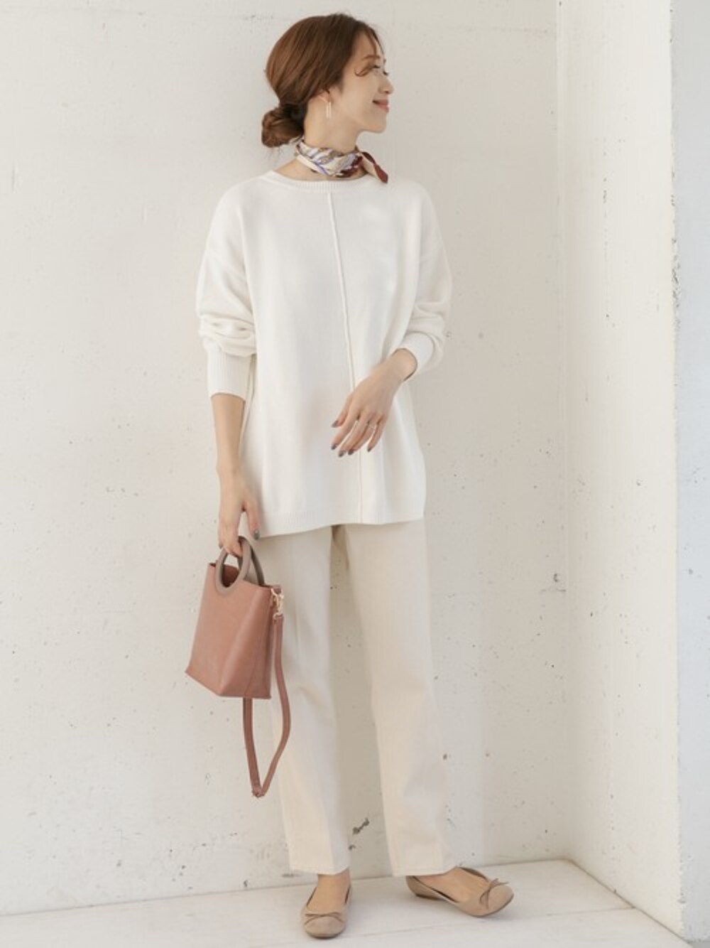 ホワイト系のニット/セーター、ベージュ系のデニムパンツ、ベージュ系のハンドバッグを着用したレディースの冬コーディネートの1枚目の写真