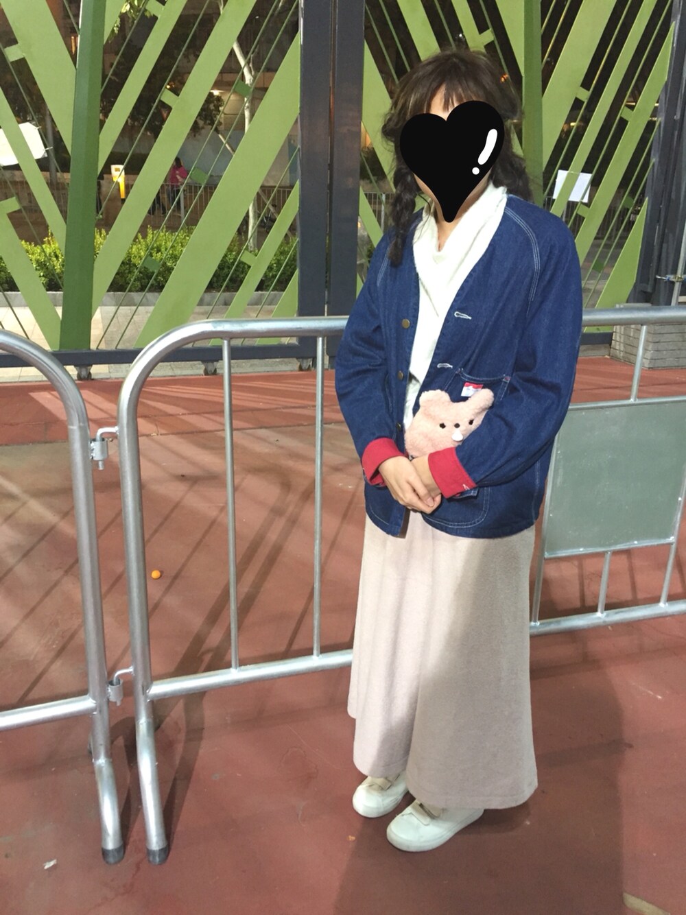 ブルー系のデニムジャケット、ホワイト系のトップス、ホワイト系のシューズを着用したレディースの冬コーディネートの1枚目の写真