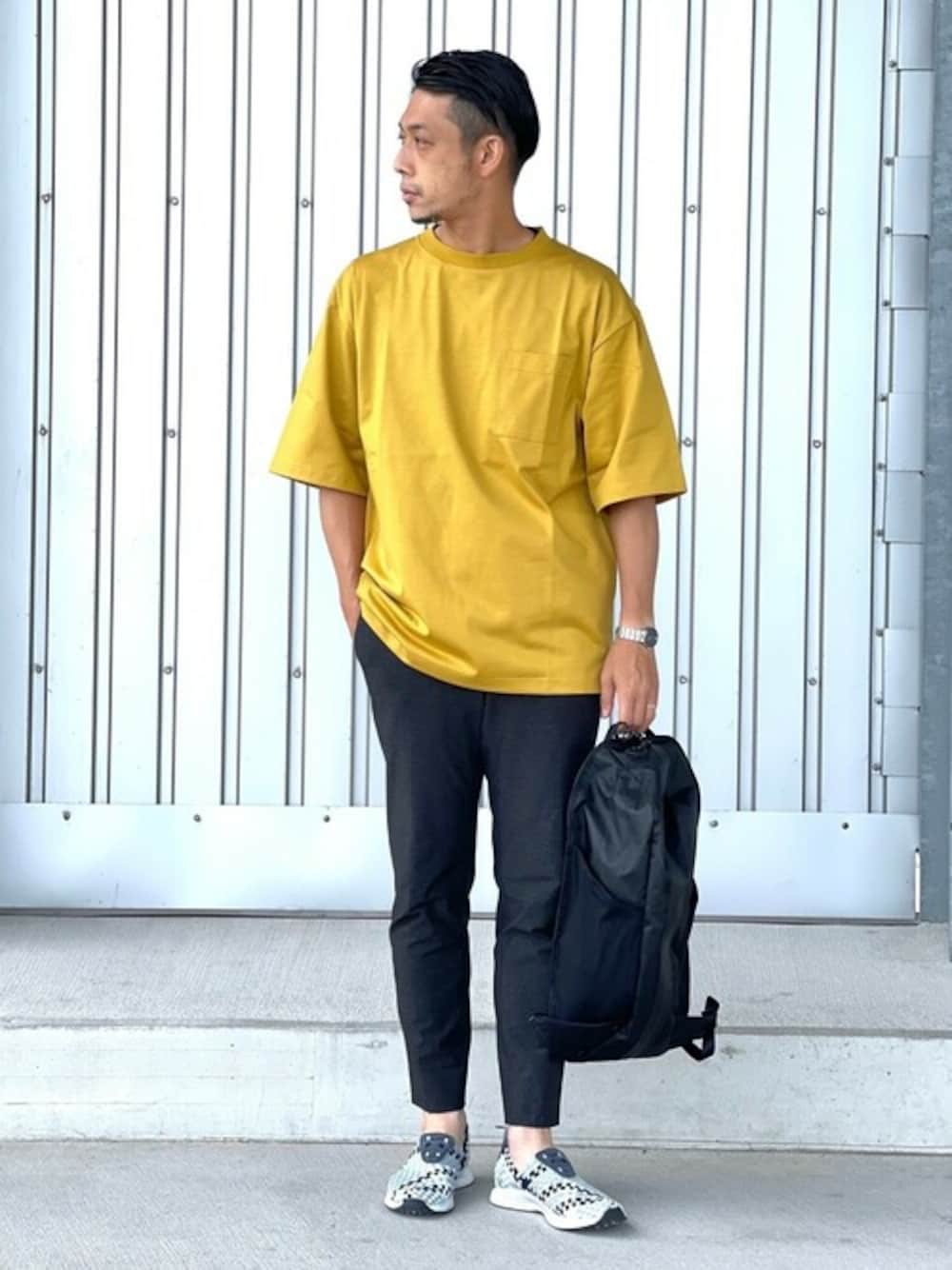 ブラック系のバックパック/リュック、イエロー系のTシャツ/カットソー、ブラック系のその他パンツを着用したメンズの夏コーディネートの1枚目の写真