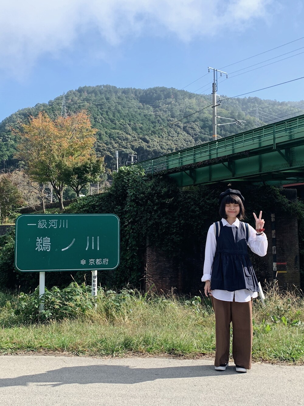 ホワイト系のシャツ/ブラウス、ブラック系のスニーカー、ブルー系のバックパック/リュックを着用したレディースの秋コーディネートの1枚目の写真