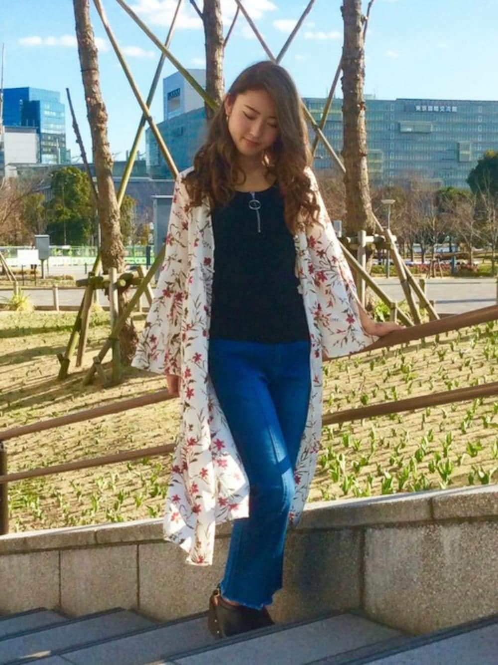 ホワイト系のワンピース、ブラック系のタンクトップ、ブルー系のデニムパンツを着用したレディースの春コーディネートの1枚目の写真