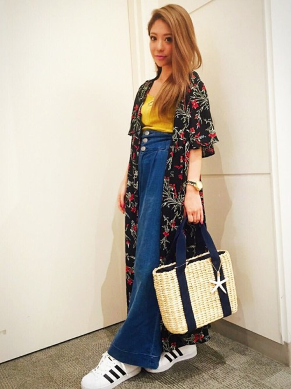 レッド系のカーディガン/ボレロ、イエロー系のタンクトップ、ブルー系のデニムパンツを着用したレディースの春コーディネートの1枚目の写真