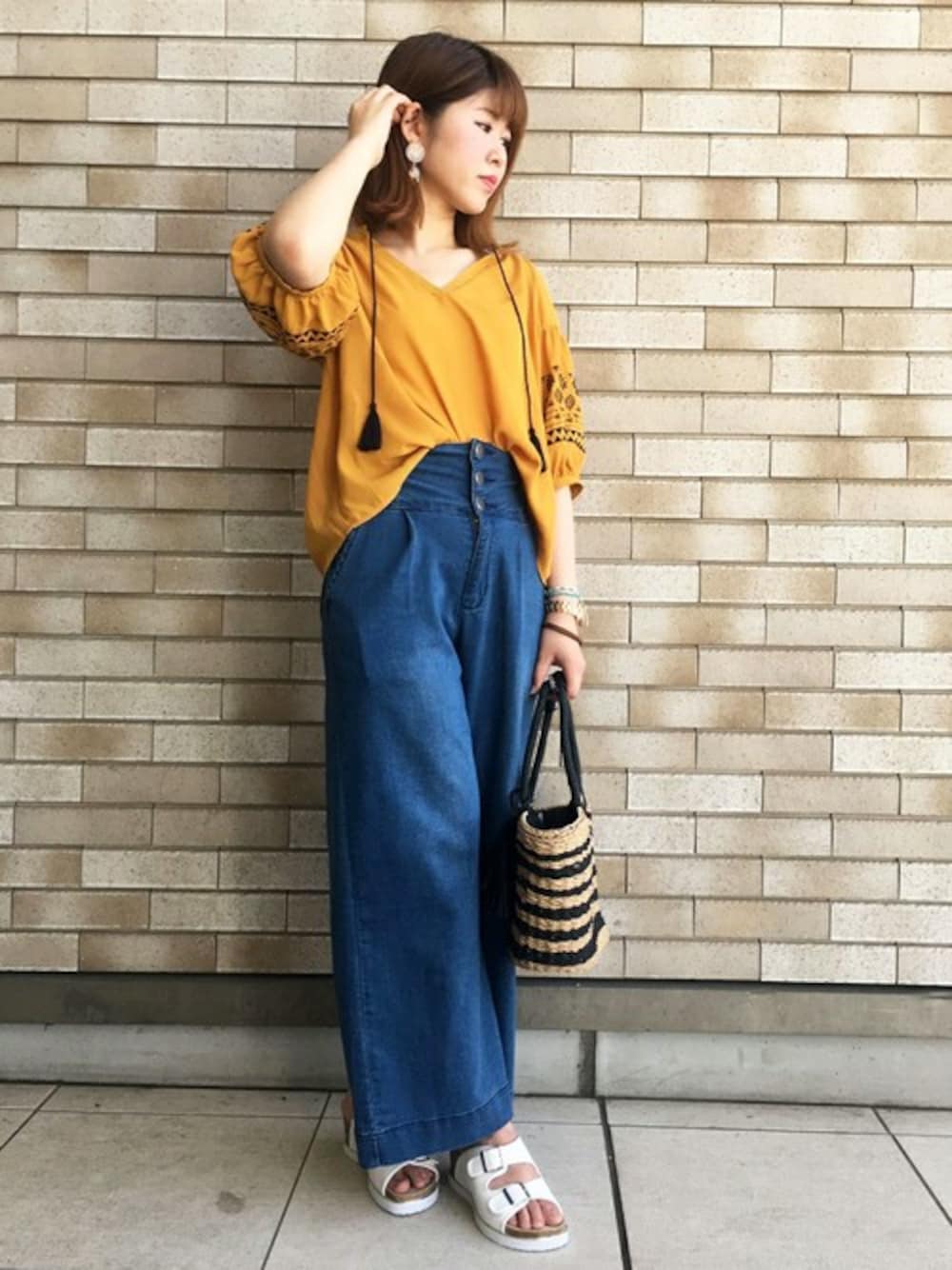 イエロー系のシャツ/ブラウス、ブルー系のデニムパンツ、ホワイト系のサンダルを着用したレディースの夏コーディネートの1枚目の写真