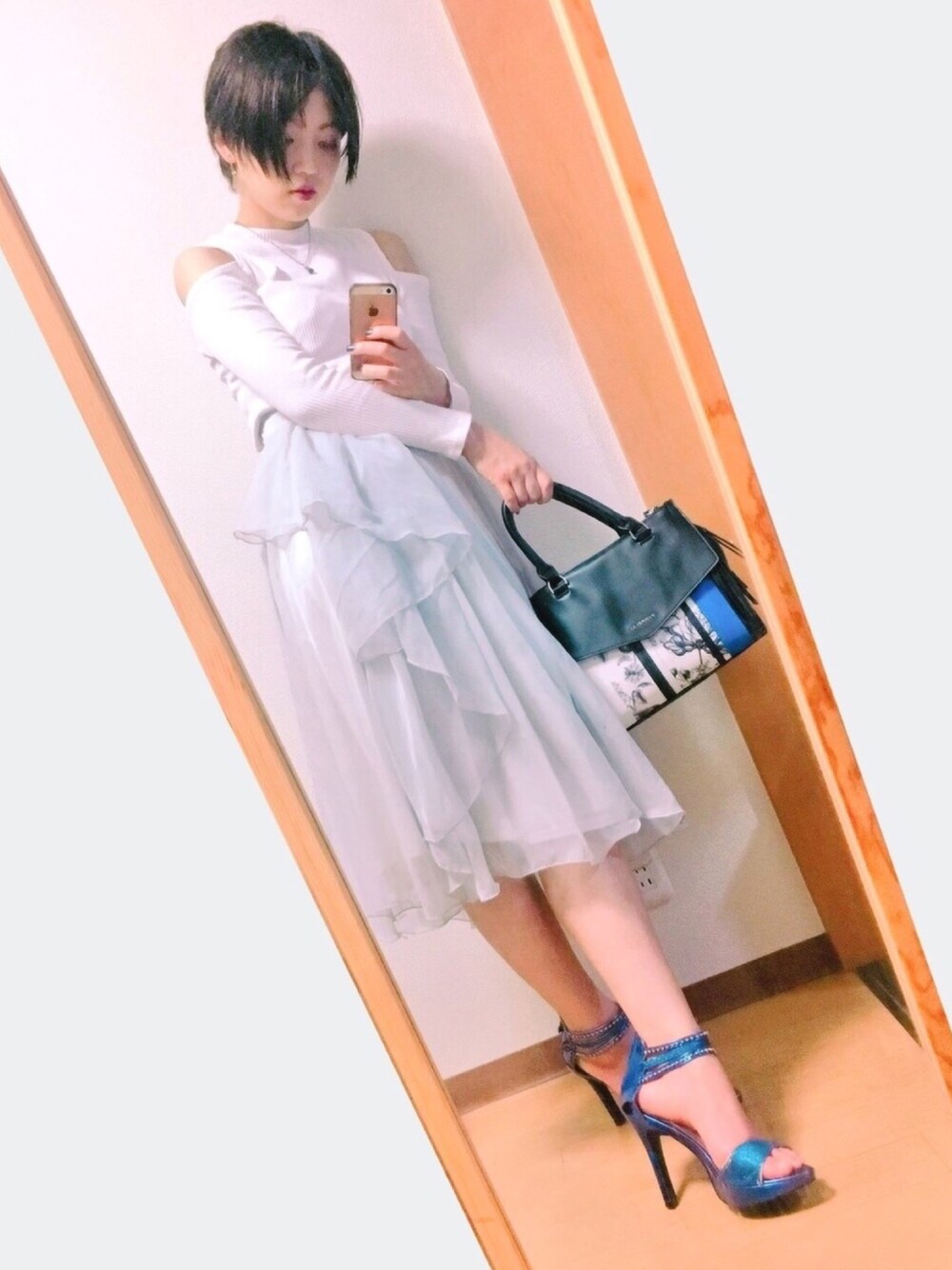 グレー系のスカート、ブルー系のボストンバッグを着用したレディースの秋コーディネートの1枚目の写真