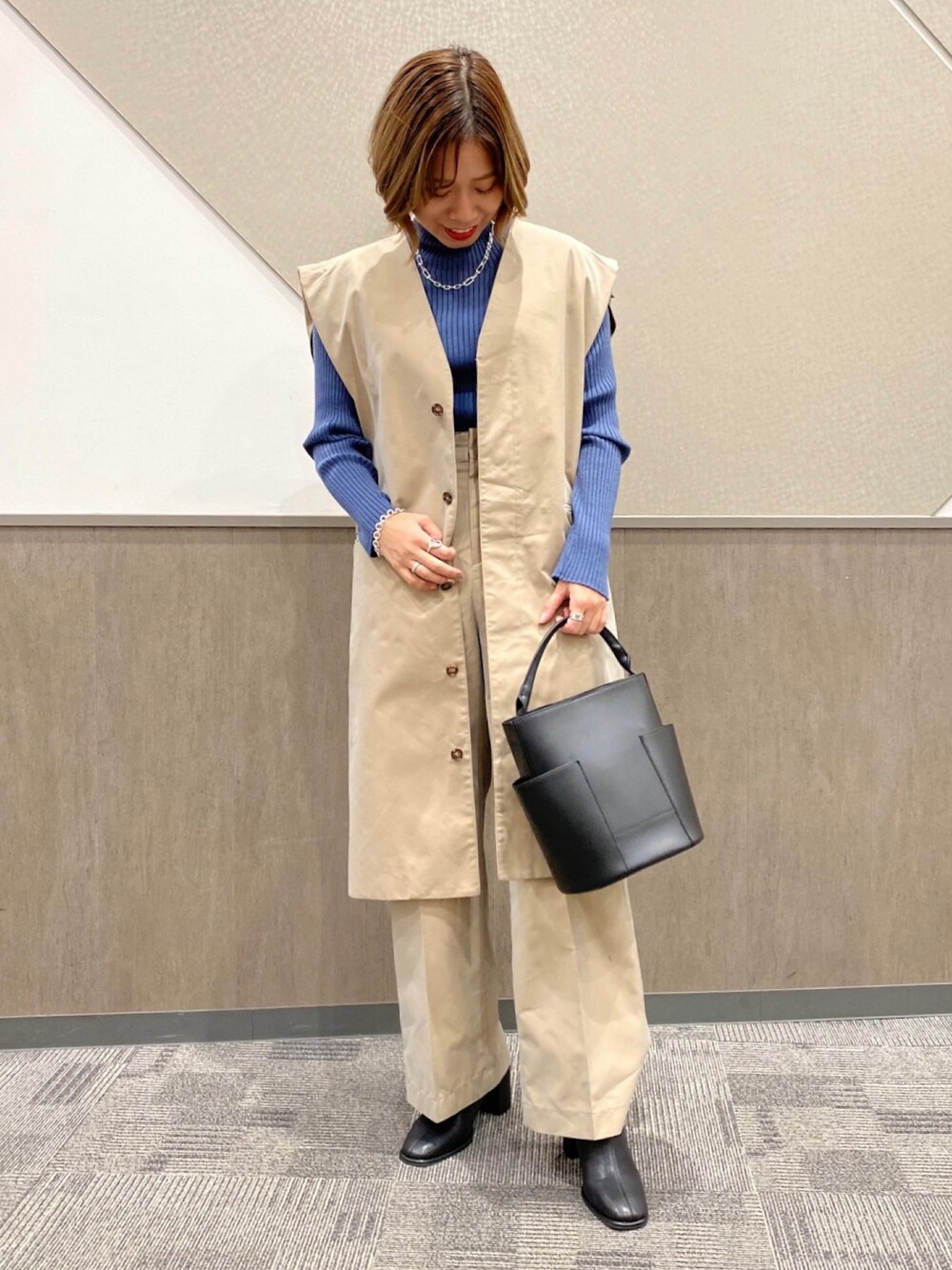 ブルー系のニット/セーター、ベージュ系のその他アウター、ベージュ系のその他パンツを着用したレディースの冬コーディネートの1枚目の写真