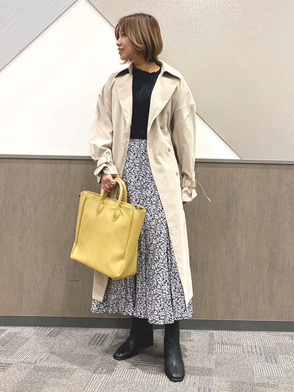 ベージュ系のトレンチコート、ブラック系のTシャツ/カットソー、ブラック系のスカートを着用したレディースの冬コーディネートの1枚目の写真