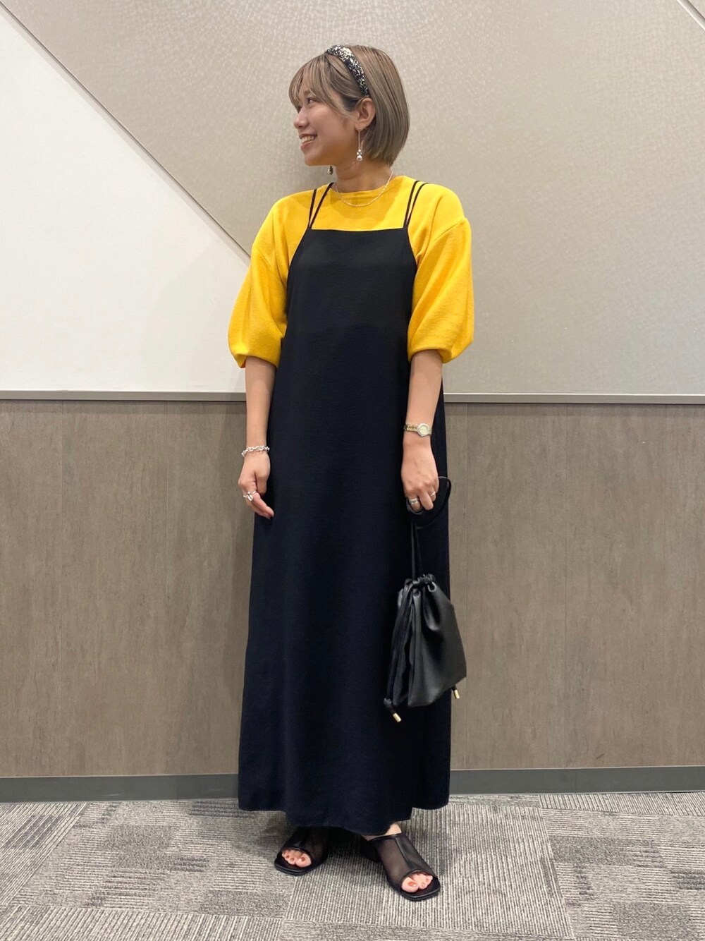 ブラック系のワンピース/ドレス、イエロー系のニット/セーター、ブラック系のショルダーバッグを着用したレディースの夏コーディネートの1枚目の写真