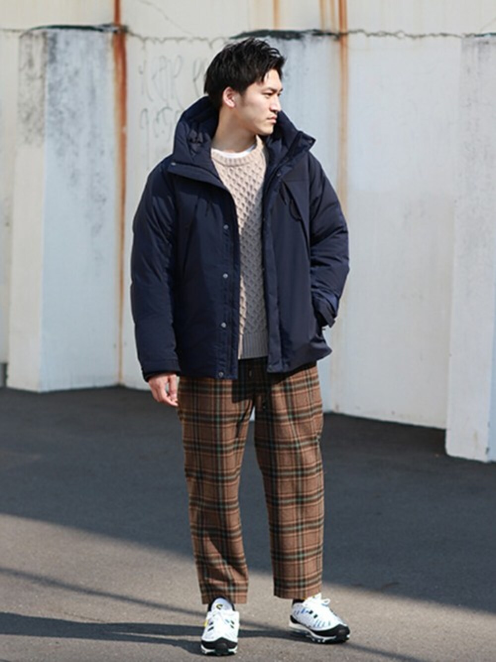 ベージュ系のニット/セーター、ブルー系のダウンジャケット/コート、ブラウン系のスラックスを着用したメンズの冬コーディネートの1枚目の写真