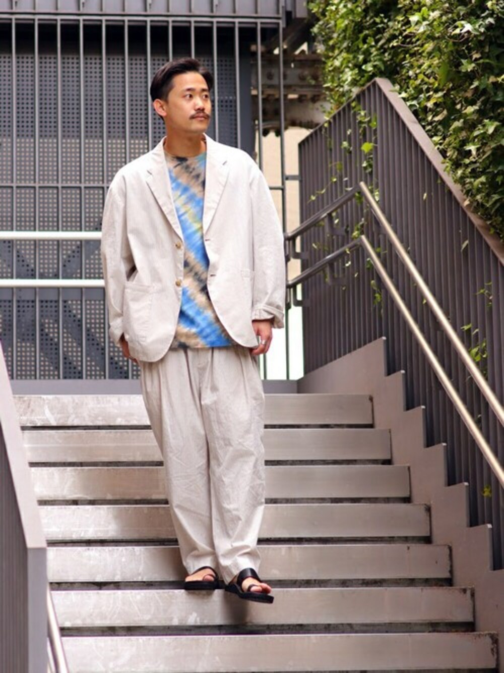 「ジャケット、セットアップ、レザー、タイダイ柄、大人カジュアル、ワイドパンツ、journal standard、サンダル、デートコーデ」｜「JOURNAL STANDARDのSLOW JACKET FAKE/S DYE（テーラードジャケット、ベージュ系）」を使った、ジャーナルスタンダード メンズさん（メンズ・173cm）の春コーディネートの1枚目の写真