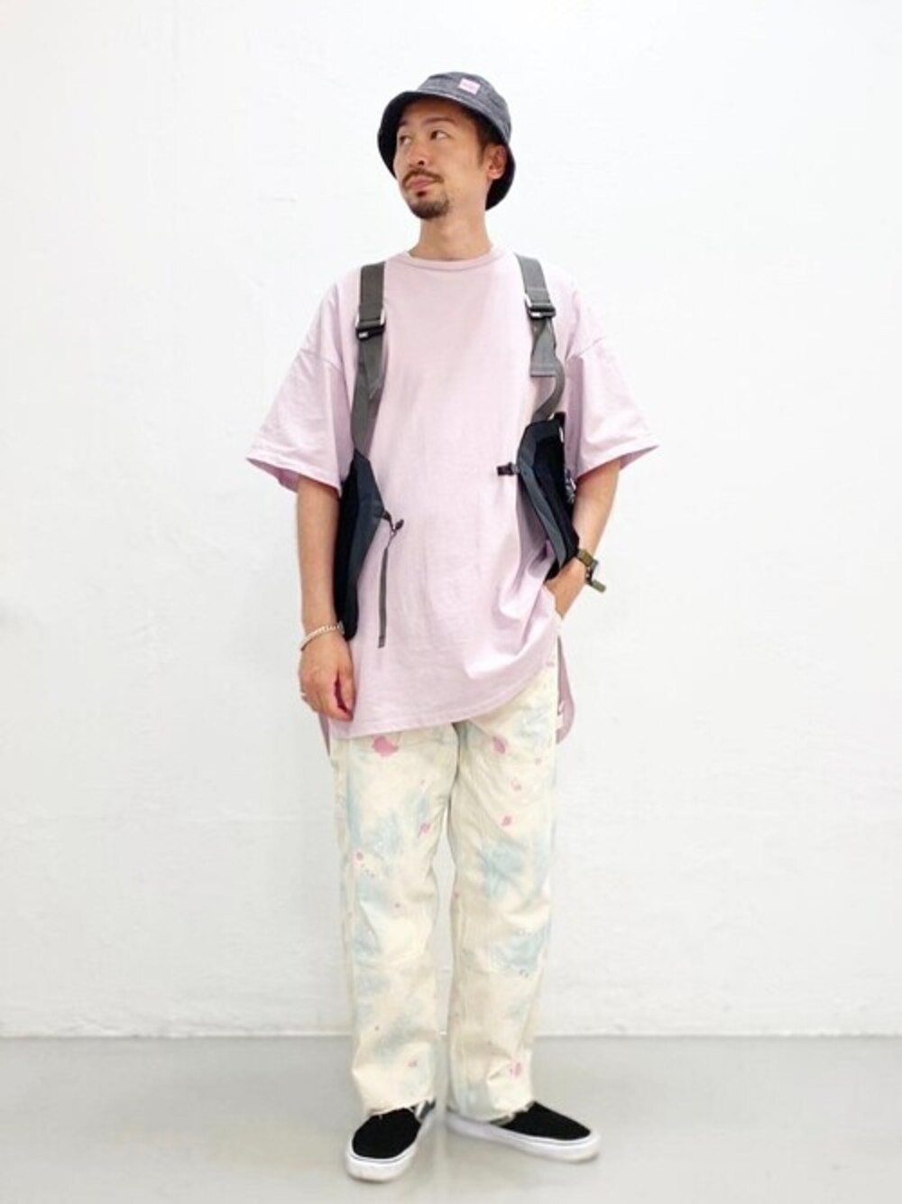 ブラック系のベスト、ピンク系のTシャツ/カットソー、グリーン系のスニーカーを着用したメンズの夏コーディネートの1枚目の写真