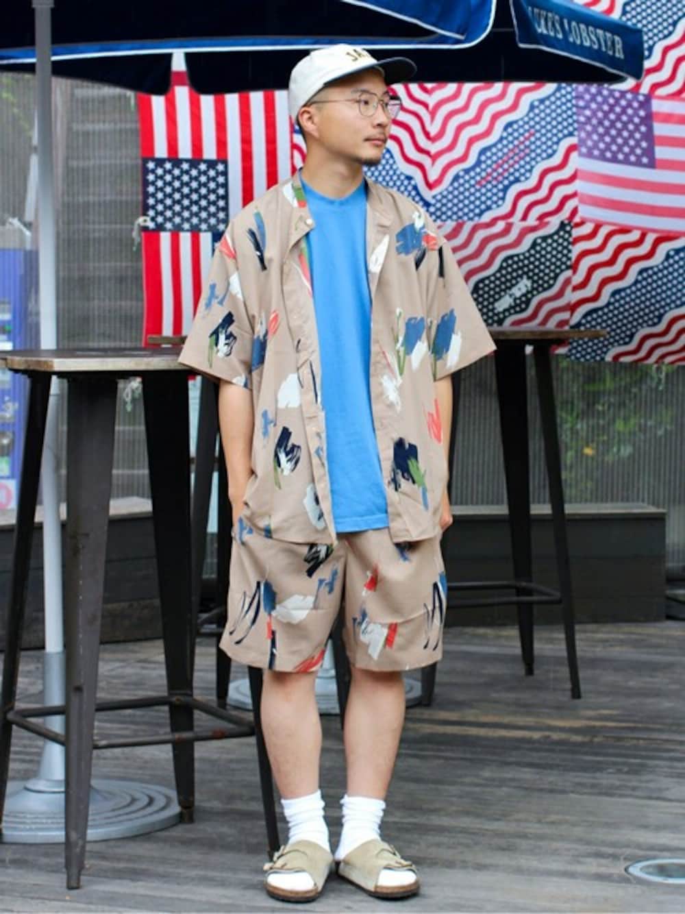 「セットアップ、柄パンツ、ブルー、柄シャツ、ショートパンツ、Tシャツ、休日スタイル、journal standard、夏コーデ、ゆるコーデ」｜「JOURNAL STANDARDの【シャツ+ショーツ+巾着袋3点セット】ホームウェア SUMMER セットアップ/部屋着/ワンマイル/オーバーサイズ/バンドカラー半袖シャツ/バギーショーツ/[10色展開/総柄/ウォールペイント/無地][ユニセックス対応]（シャツ/ブラウス、ベージュ系）」を使った、ジャーナルスタンダード メンズさん（メンズ・168cm）の夏コーディネートの1枚目の写真