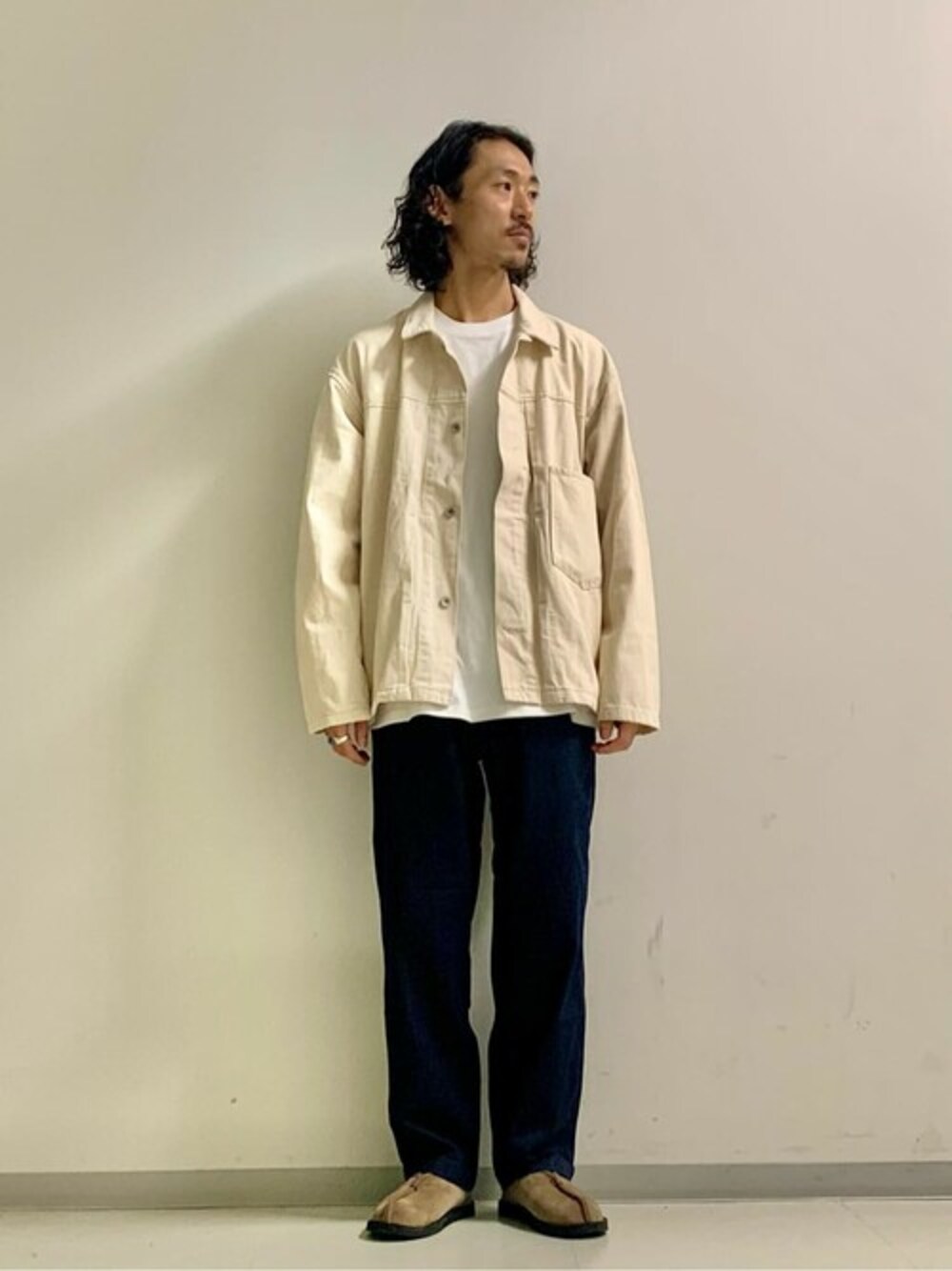 ベージュ系のデニムジャケット、ブルー系のTシャツ/カットソー、ブルー系のデニムパンツを着用したメンズの秋コーディネートの1枚目の写真