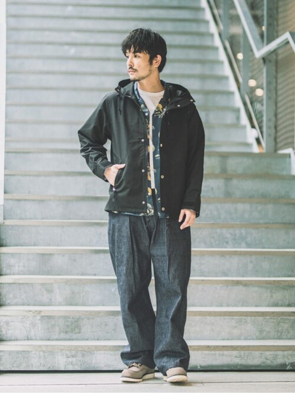 ブラック系のマウンテンパーカー、グレー系のTシャツ/カットソー、ブルー系のシャツ/ブラウスを着用したメンズの秋コーディネートの1枚目の写真