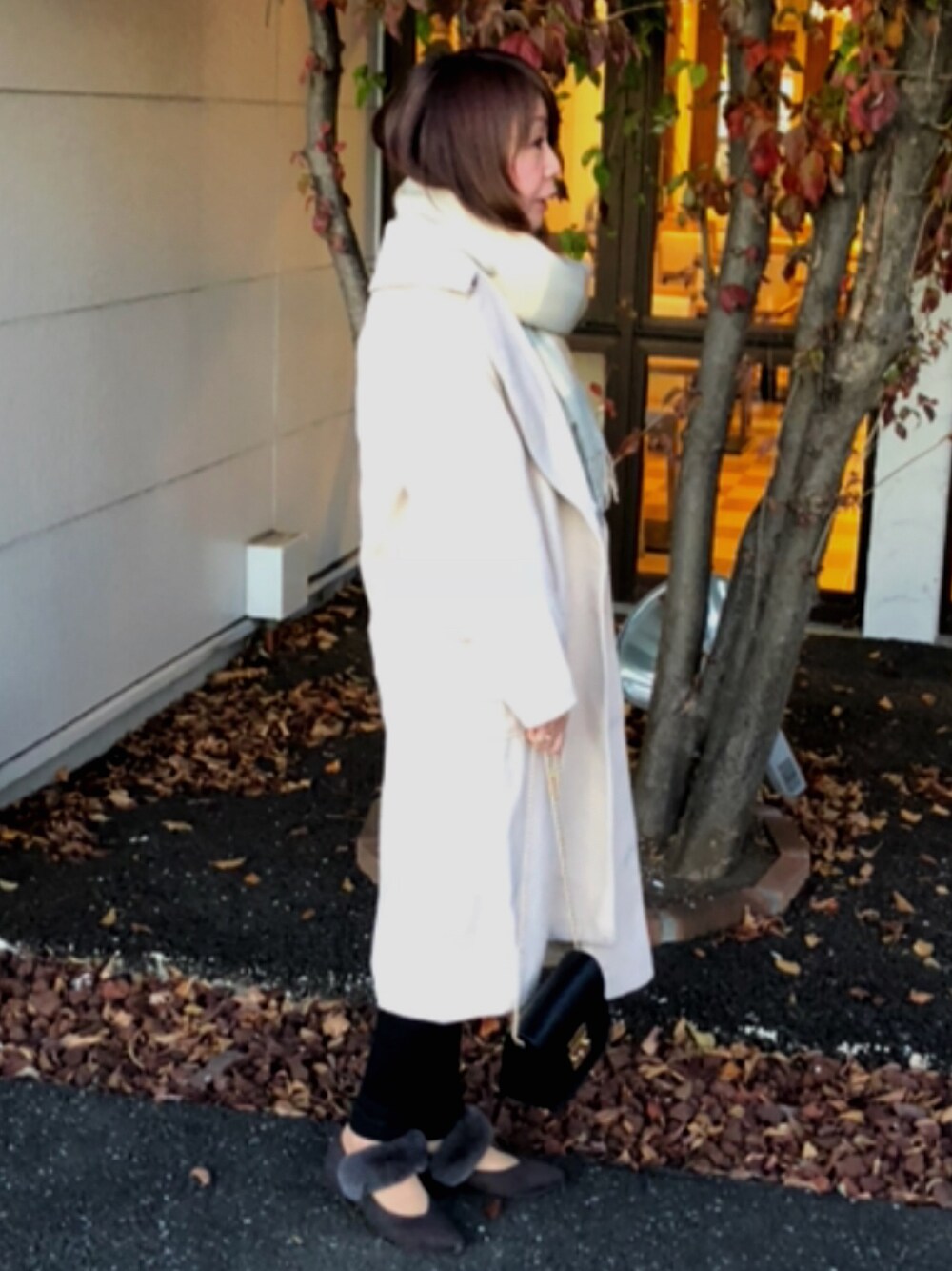 ベージュ系のチェスターコート、ブラック系のその他パンツ、グレー系のパンプスを着用したレディースの冬コーディネートの1枚目の写真