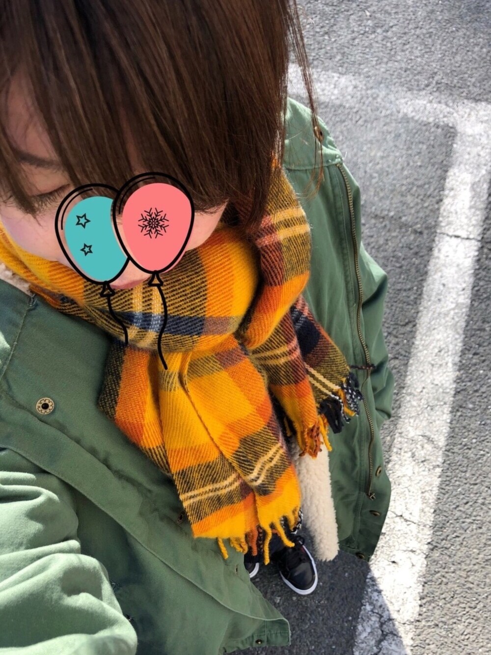 グリーン系のモッズコート、ブラック系のスニーカー、イエロー系のストール/ショールを着用したレディースの冬コーディネートの1枚目の写真