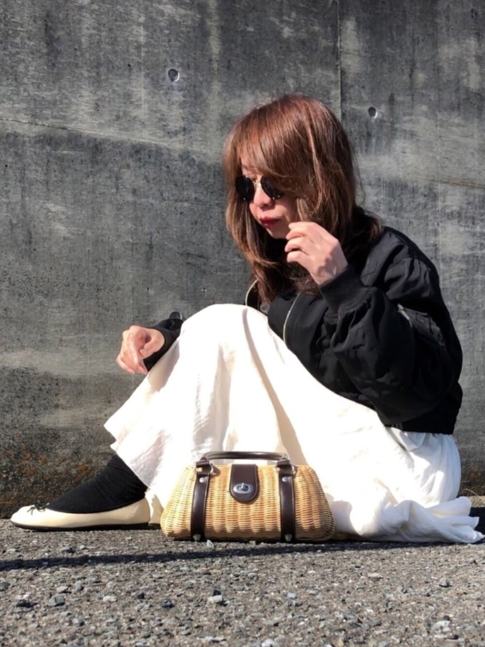 ブラック系のシャツ/ブラウス、ブラウン系のハンドバッグ、ホワイト系のスカートを着用したレディースの春コーディネートの1枚目の写真