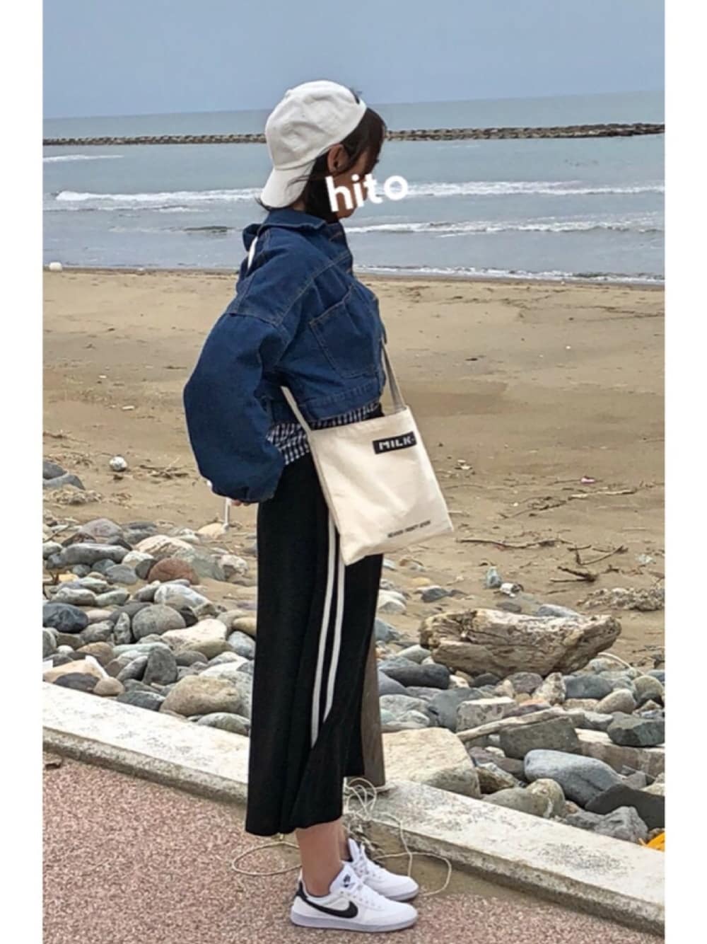 その他のショルダーバッグ、ホワイト系のスニーカー、ブラック系のスカートを着用したレディースの春コーディネートの1枚目の写真