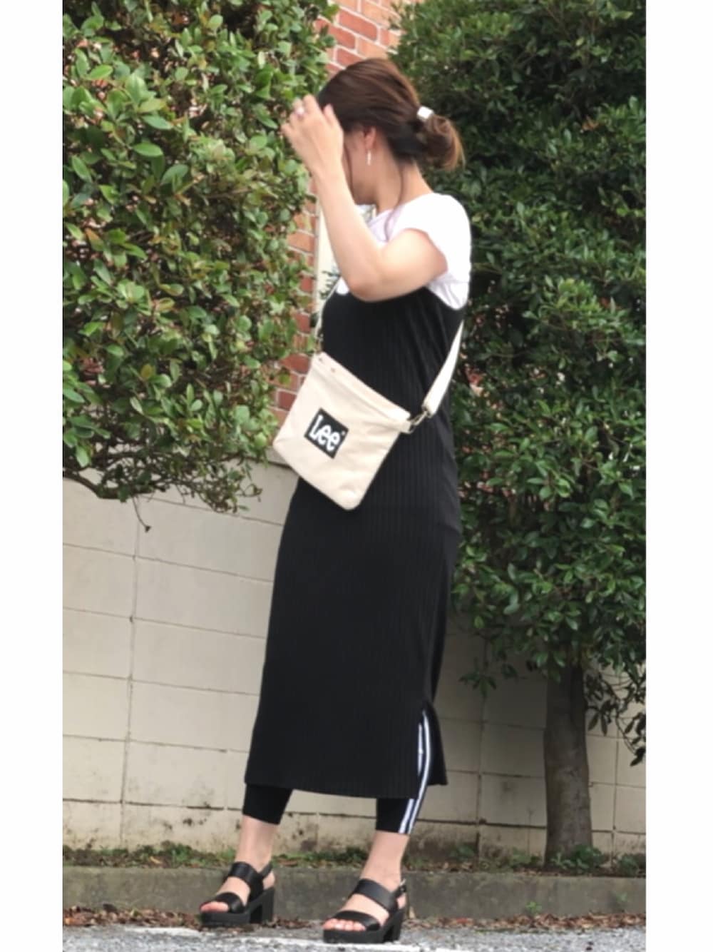 ホワイト系のショルダーバッグ、ブラック系のサンダル、ブラック系のその他パンツを着用したレディースの夏コーディネートの1枚目の写真