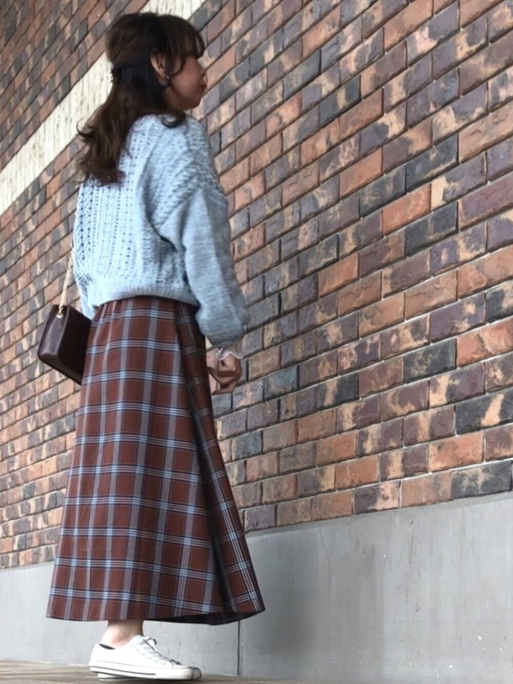 グリーン系のカーディガン/ボレロ、ブラウン系のスカート、ホワイト系のTシャツ/カットソーを着用したレディースの秋コーディネートの1枚目の写真