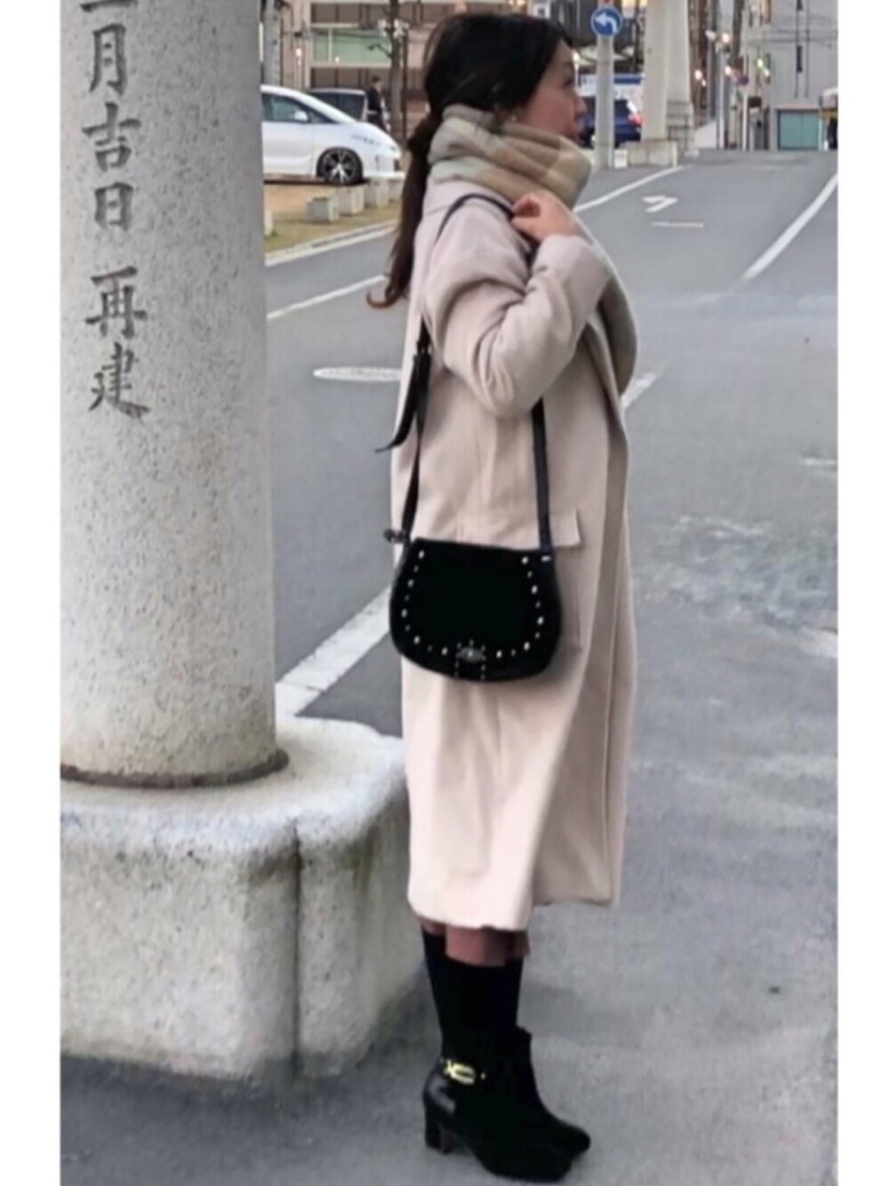 ブラック系のショルダーバッグ、ベージュ系のチェスターコート、ベージュ系のスウェットを着用したレディースの冬コーディネートの1枚目の写真