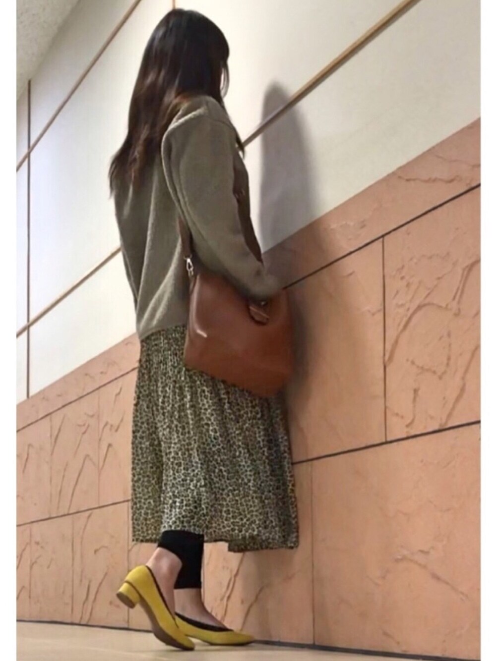 ブラウン系のショルダーバッグ、イエロー系のパンプス、ベージュ系のノーカラージャケットを着用したレディースの冬コーディネートの1枚目の写真