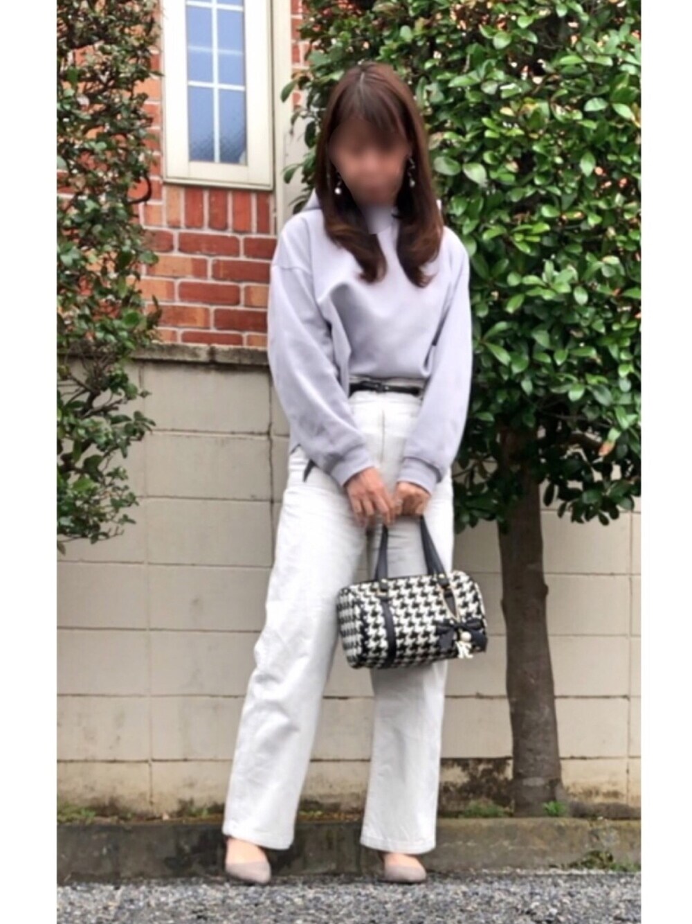 グレー系のデニムパンツ、グレー系のパーカー、ブラック系のショルダーバッグを着用したレディースの冬コーディネートの1枚目の写真