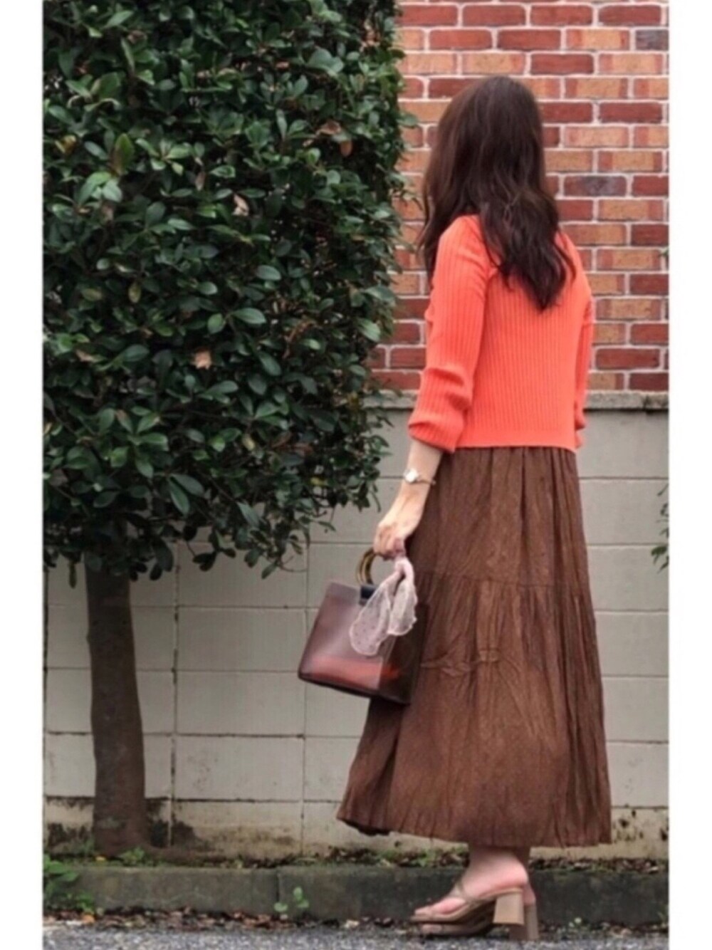 ブラウン系のワンピース、ブラウン系のバッグ、ブラウン系のサンダルを着用したレディースの夏コーディネートの1枚目の写真