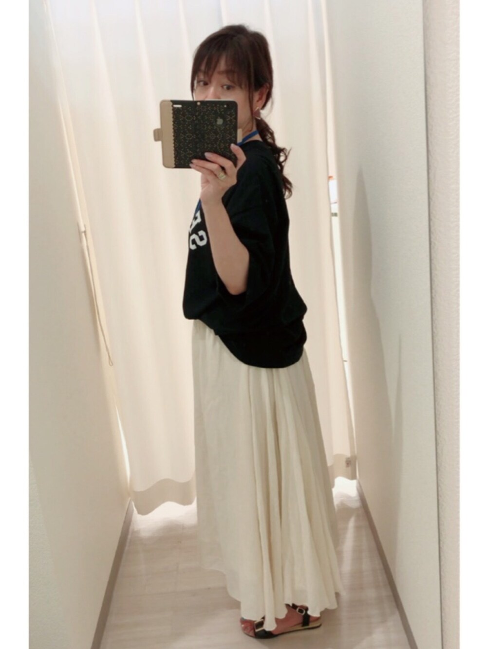 ブラック系のTシャツ/カットソー、ホワイト系のスカート、ブラック系のサンダルを着用したレディースの夏コーディネートの1枚目の写真