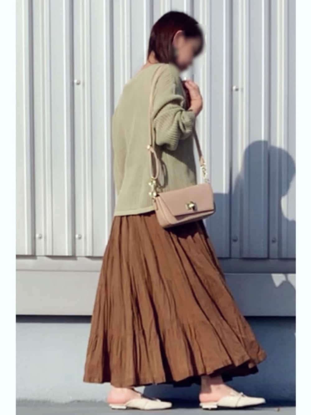 ブラウン系のスカート、ホワイト系のその他シューズ、グリーン系のニット/セーターを着用したレディースの春コーディネートの1枚目の写真