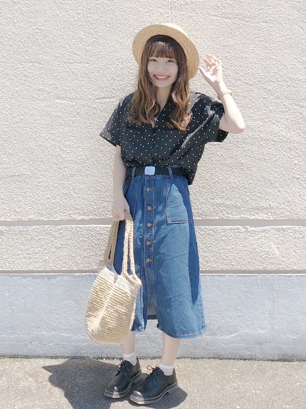 ベージュ系のトートバッグ、ブルー系のデニムスカート、ブラック系のローファーを着用したレディースの夏コーディネートの1枚目の写真