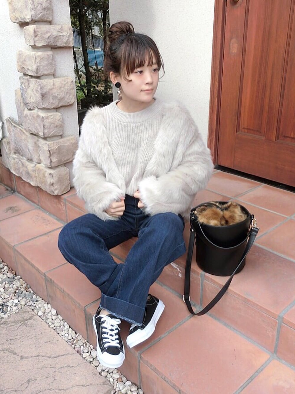 ベージュ系のその他アウター、ベージュ系のニット/セーター、ブルー系のデニムパンツを着用したレディースの冬コーディネートの1枚目の写真