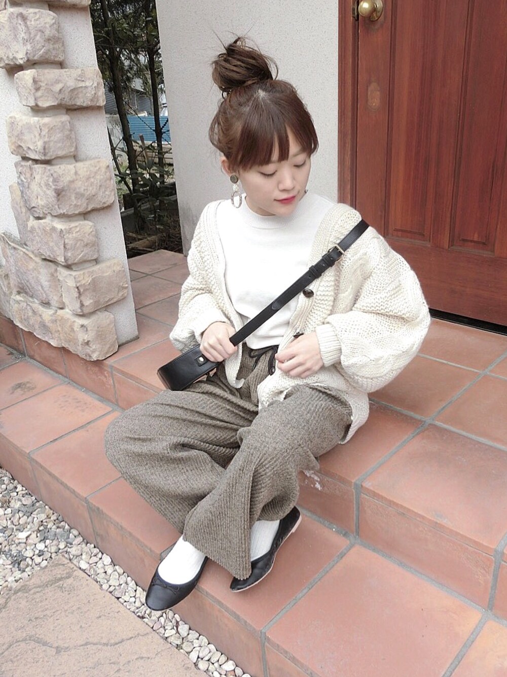 ベージュ系のニット/セーター、ブラック系のバレエシューズ、ホワイト系のカーディガン/ボレロを着用したレディースの冬コーディネートの1枚目の写真