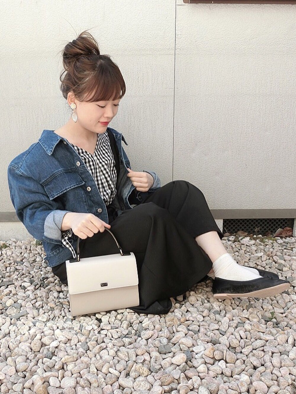 ブラック系のシャツ/ブラウス、ブルー系のデニムジャケット、ベージュ系のハンドバッグを着用したレディースの春コーディネートの1枚目の写真