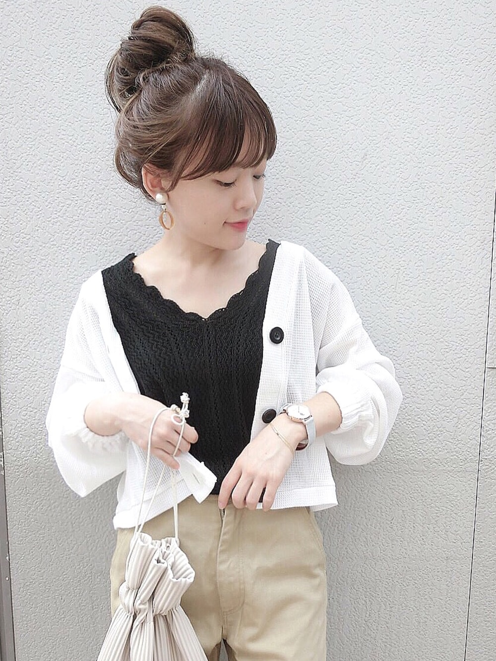 ブラック系のニット/セーター、ホワイト系のカーディガン/ボレロ、ベージュ系のデニムパンツを着用したレディースの夏コーディネートの1枚目の写真