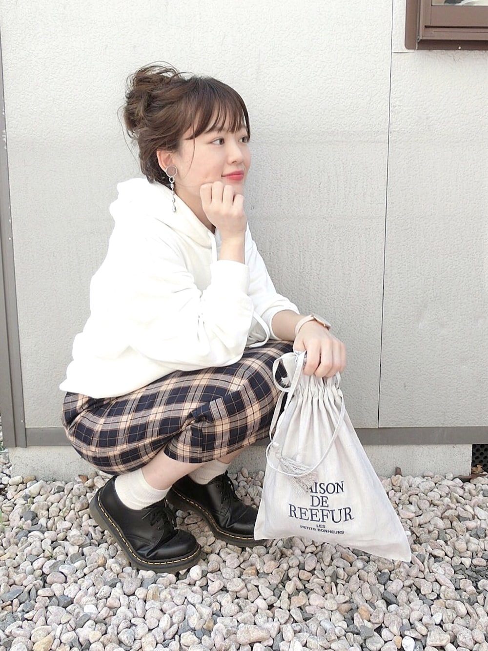 ホワイト系のパーカー、ブルー系のスカート、ブラック系のブーツを着用したレディースの秋コーディネートの1枚目の写真