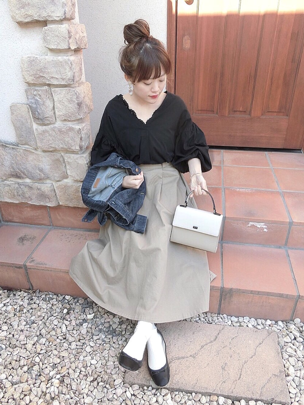 ブラック系のシャツ/ブラウス、ベージュ系のスカート、ブラック系のバレエシューズを着用したレディースの春コーディネートの1枚目の写真