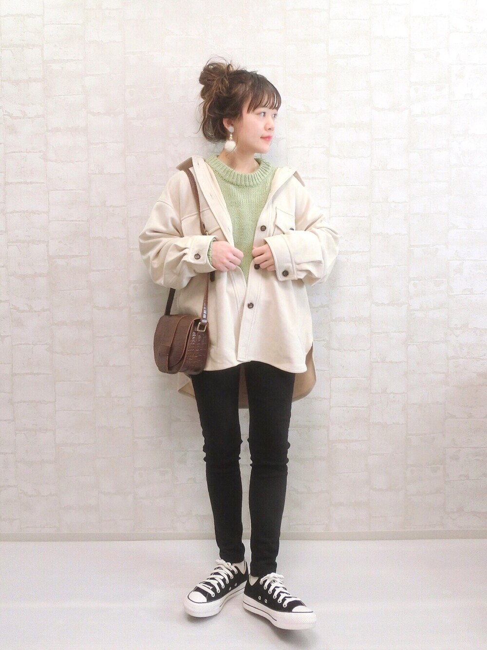 ベージュ系のカバーオール、グリーン系のニット/セーター、ブラック系のその他パンツを着用したレディースの冬コーディネートの1枚目の写真