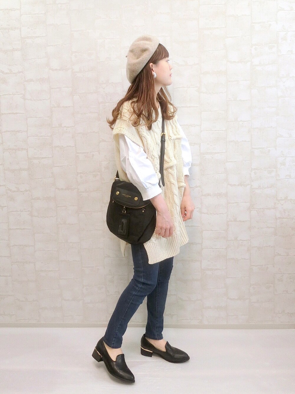 ホワイト系のベスト、ホワイト系のTシャツ/カットソー、ブルー系のパンツを着用したレディースの秋コーディネートの1枚目の写真