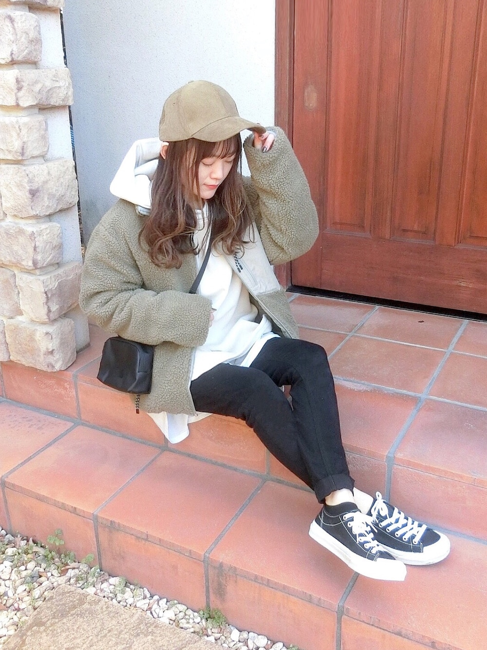 ベージュ系のパーカー、グレー系のブルゾン、ブラック系のその他パンツを着用したレディースの冬コーディネートの1枚目の写真