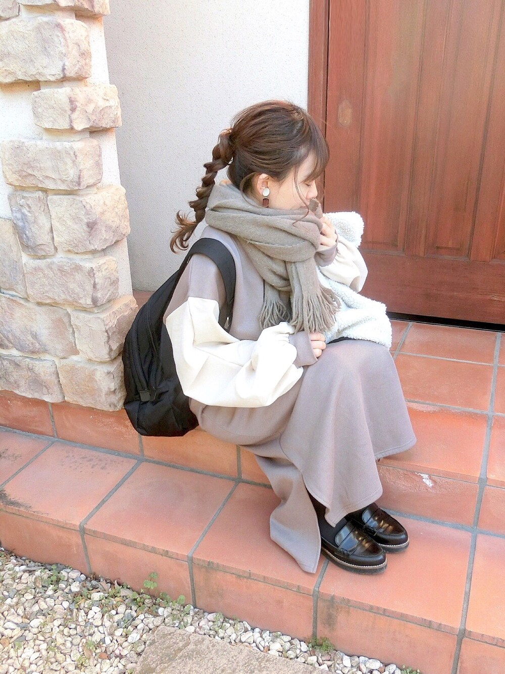 ブラウン系のワンピース、ブラック系のパンプス、ホワイト系のブルゾンを着用したレディースの冬コーディネートの1枚目の写真