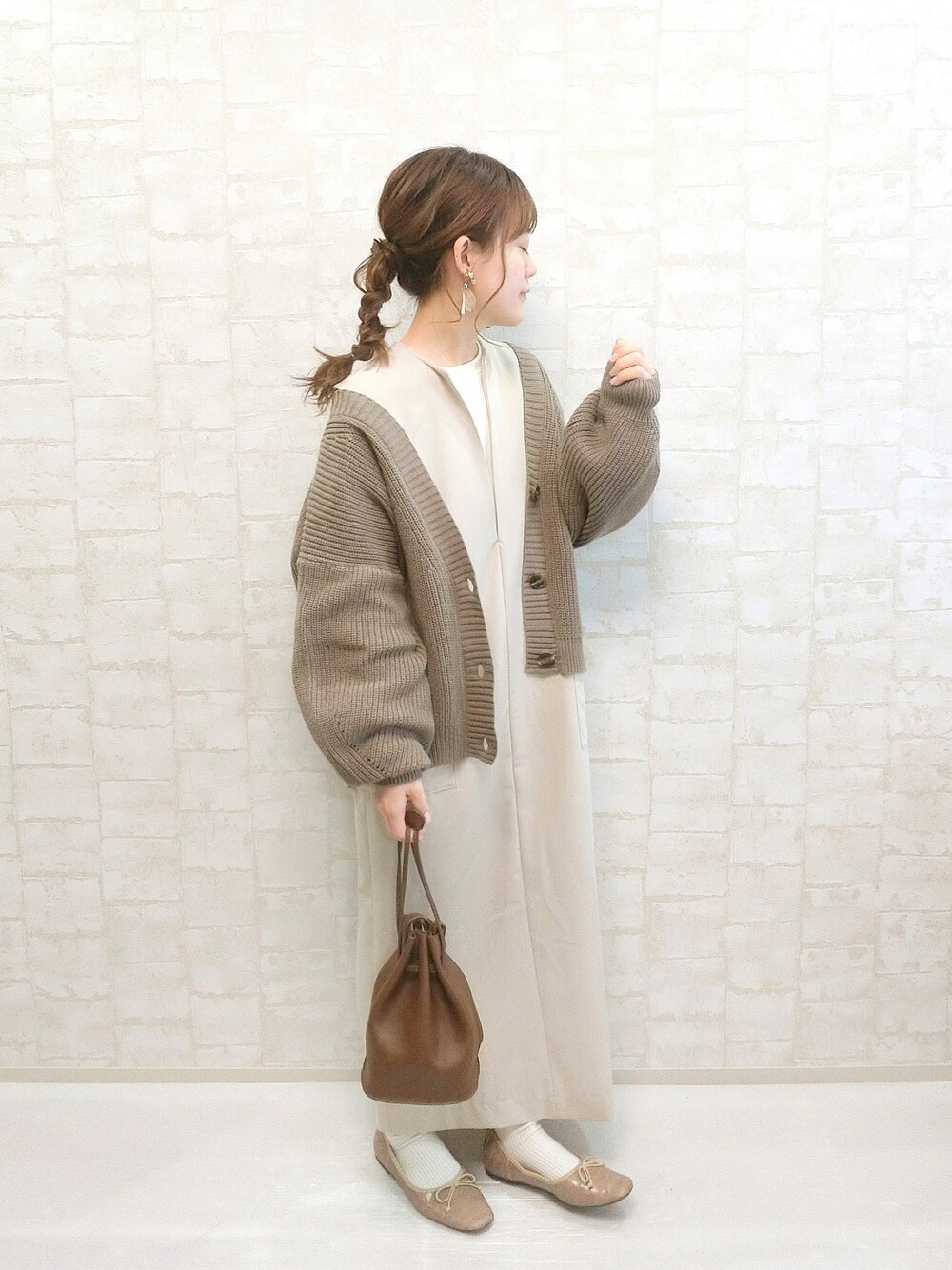 ベージュ系のワンピース、ブラウン系のカーディガン/ボレロ、ブラウン系のショルダーバッグを着用したレディースの春コーディネートの1枚目の写真