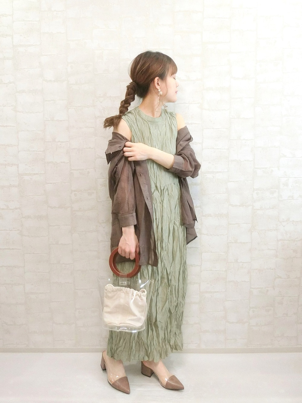 グリーン系のワンピース、ブラウン系のシャツ/ブラウス、ブラウン系のサンダルを着用したレディースの春コーディネートの1枚目の写真