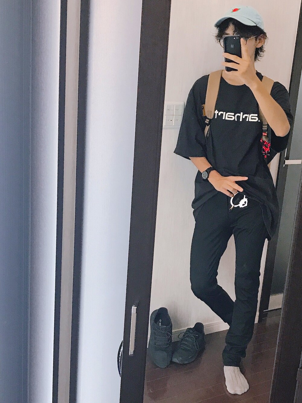 ブラック系のTシャツ/カットソー、イエロー系のバックパック/リュック、ブラック系のパンツを着用したメンズの夏コーディネートの1枚目の写真