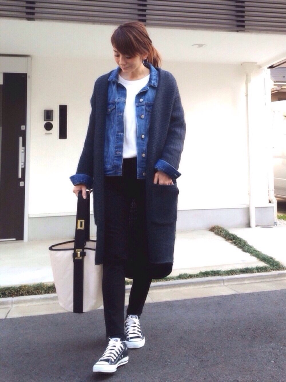 ブラック系のスニーカー、ブルー系のカーディガン/ボレロ、ブルー系のデニムジャケットを着用したレディースの春コーディネートの1枚目の写真