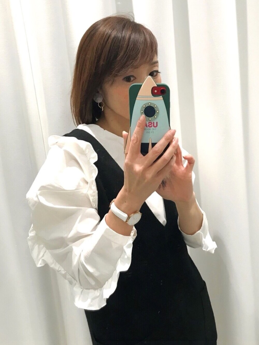 ブラック系のワンピース、ホワイト系のシャツ/ブラウス、ピンク系のスマホケース/カバーを着用したレディースの冬コーディネートの1枚目の写真