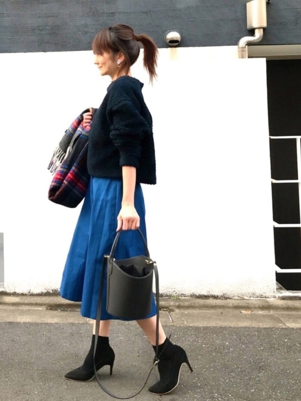 ブルー系のその他トップス、ブルー系のスカート、ブラック系のショルダーバッグを着用したレディースの冬コーディネートの1枚目の写真